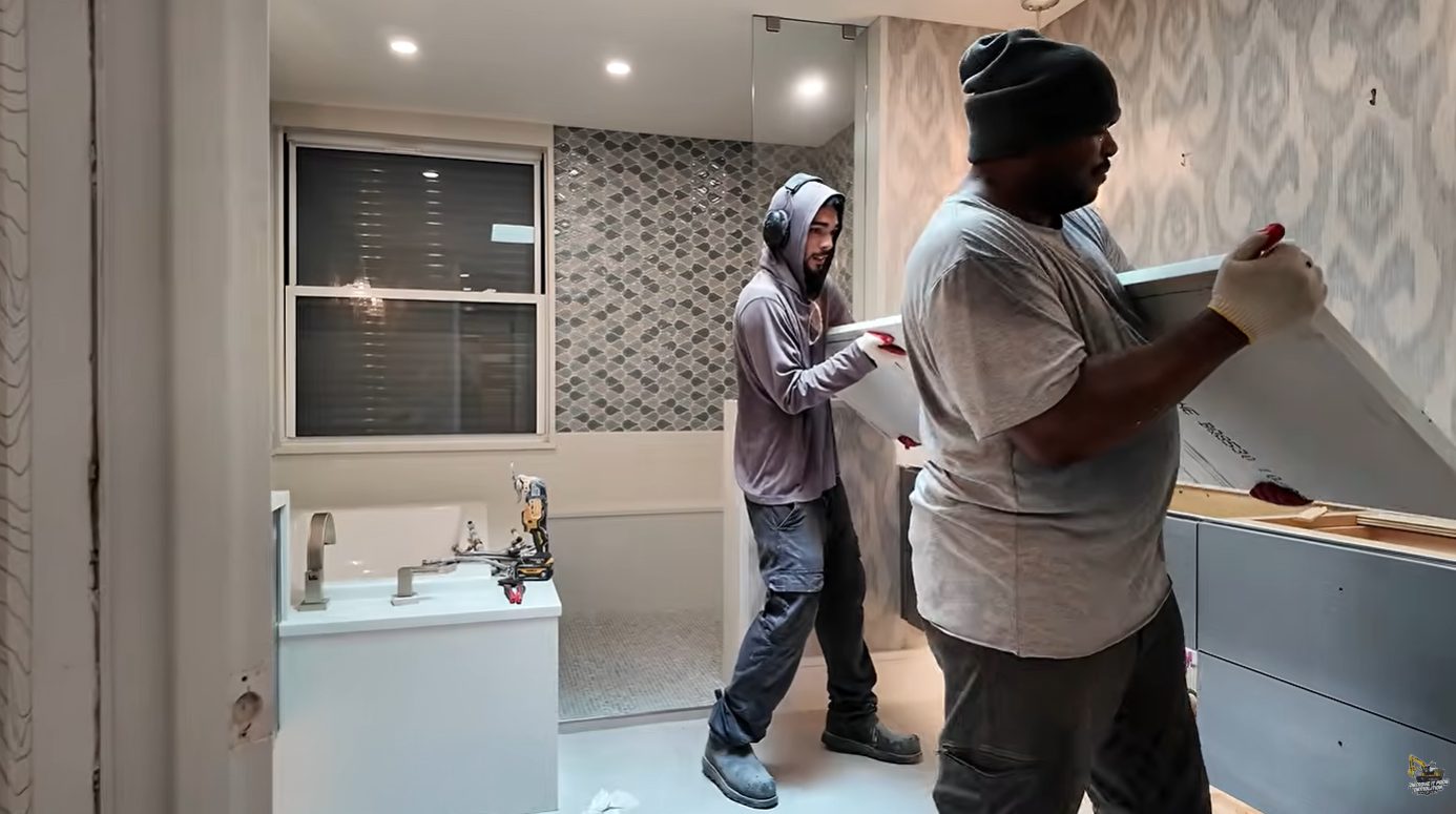 Remove It Pros crew removing a bathroom vanity top during selective demolition in a luxury condo