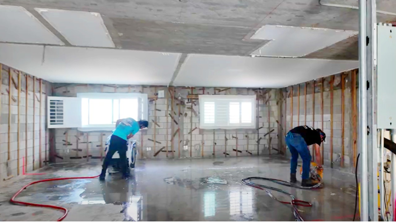 Two Remove It Pros technicians concrete cutting a floor slab inside a home under construction