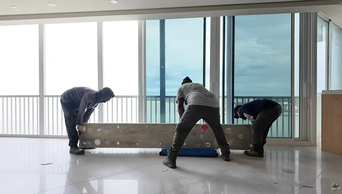 Three-man Remove It Pros crew removing a stone countertop slab in a Gulf-front condo